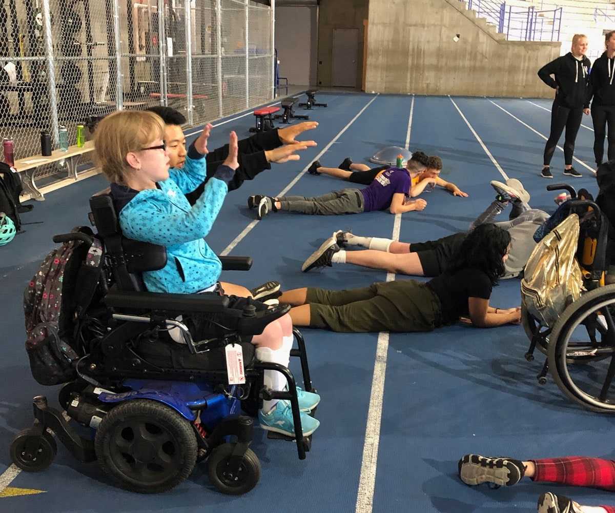 A group of kids at a running track stretching