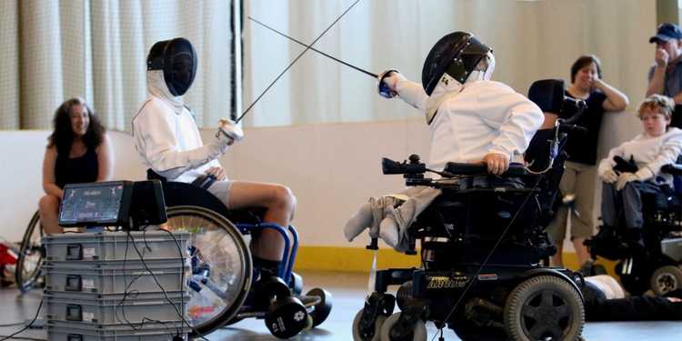 Kids in wheel chairs playing fencing.