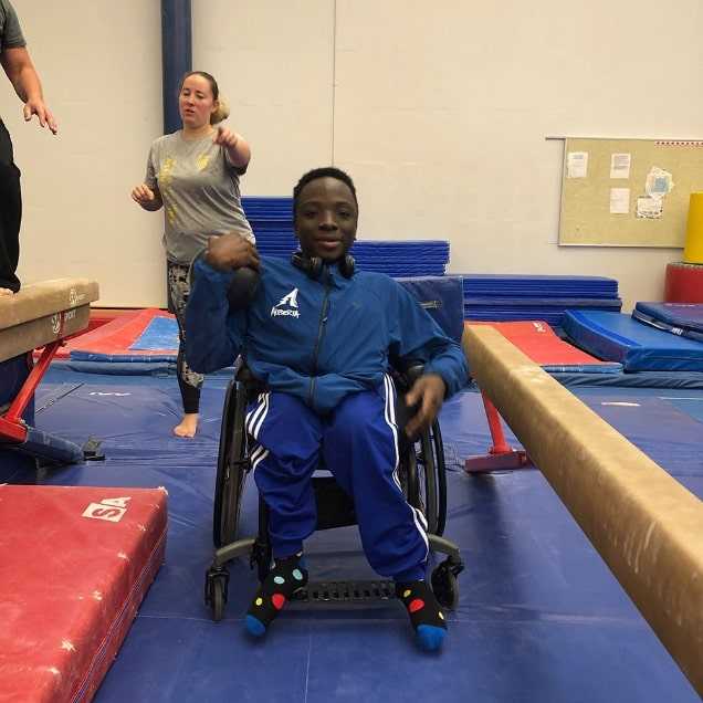 a child in a wheelchair in a gymnastics gym area